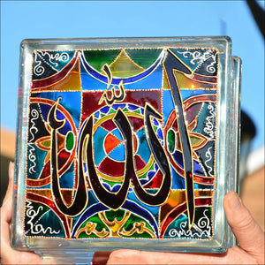 Two hands holding a colourful glass block night light / suncatcher with an intricate Islamic design and large Allah symbol