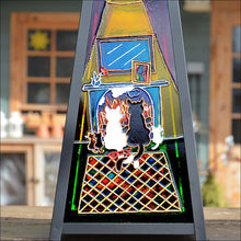 A loving cat family cuddle up to the warmth of a colourful winter fireside on this unique hand painted candle lantern