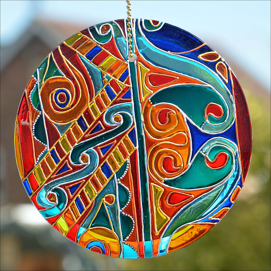 A hanging circle suncatcher by Ornately Lanterns hand painted with a colourful Celtic Knots design onto glass