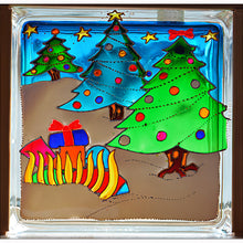A stained glass block mantel ornament with Christmas trees in the snow and a golden sleigh filled with colourful festive gifts