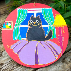 Plywood circle wall hanging hand painted in bright cheerful colours; fluffy black cat on purple cushion art; cat lover gift