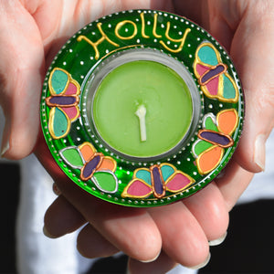 7.	A stained glass tealight candle holder hand painted in bright green with colourful butterflies, personalised for Holly