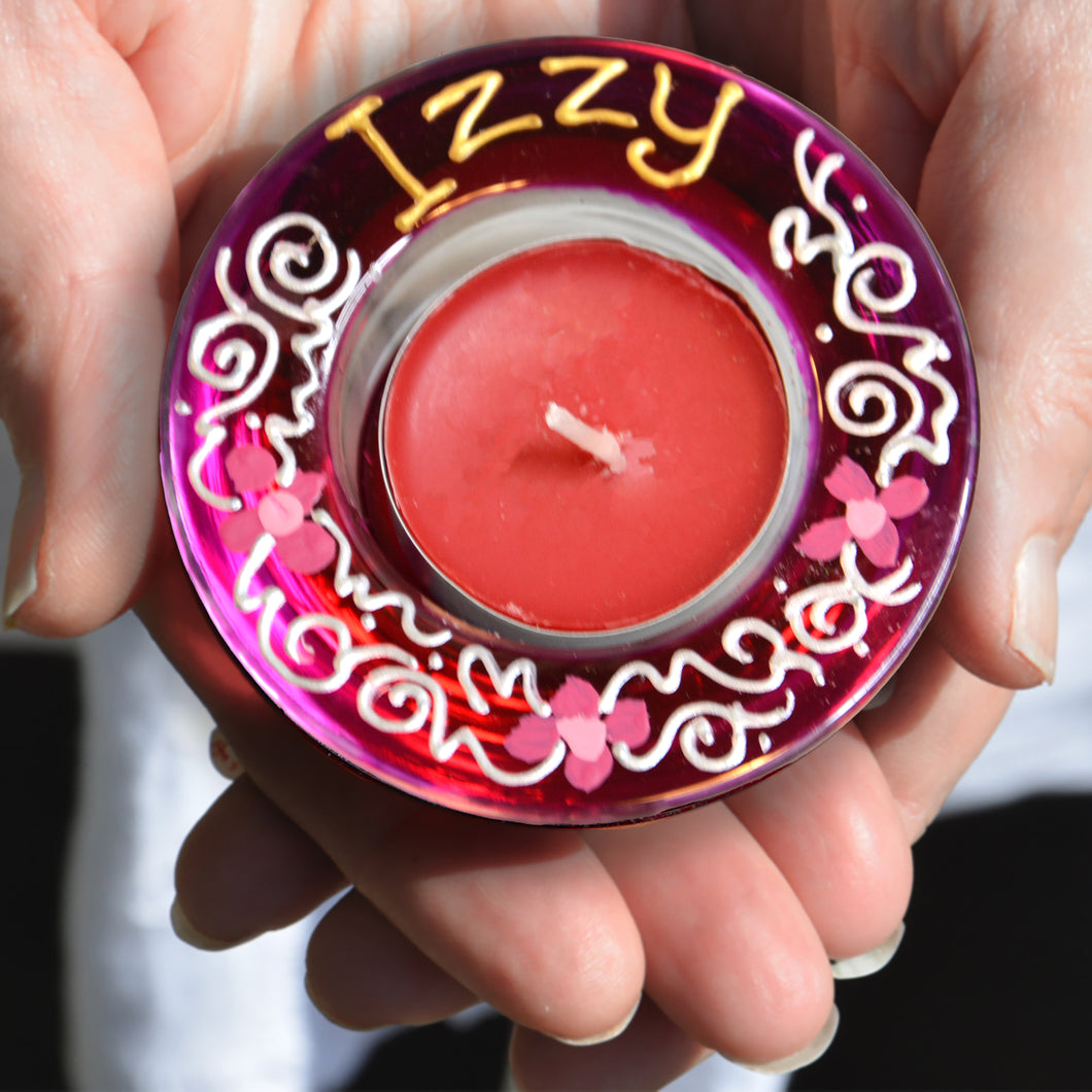 A stained glass tealight candle holder hand painted in fuchsia pink with tiny pink daisy flowers, personalised for Izzy