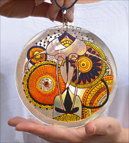 Stained glass hanging suncatcher with a detailed ornate mandala design, hand painted in gold, sunshine yellow and warm orange