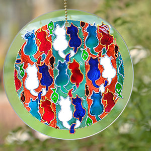 A stained glass suncatcher by Ornately Lanterns shows nine cat couples painted in Turkish Delight colours:  pink, blue and white